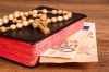 © GieZetStudio - stock.adobe.com Foto: Bibel und Geldscheine